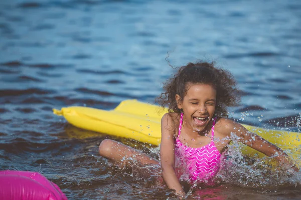 African american girl on inflatable mattress — Stock Photo, Image