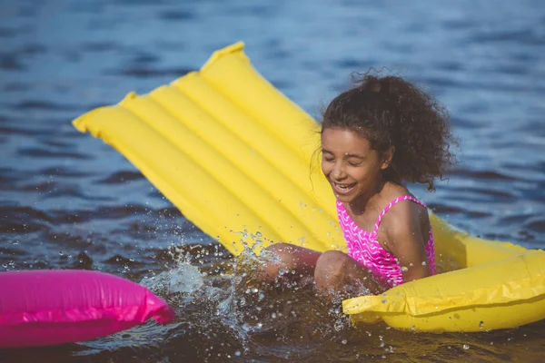 Chica afroamericana en colchón inflable — Foto de Stock