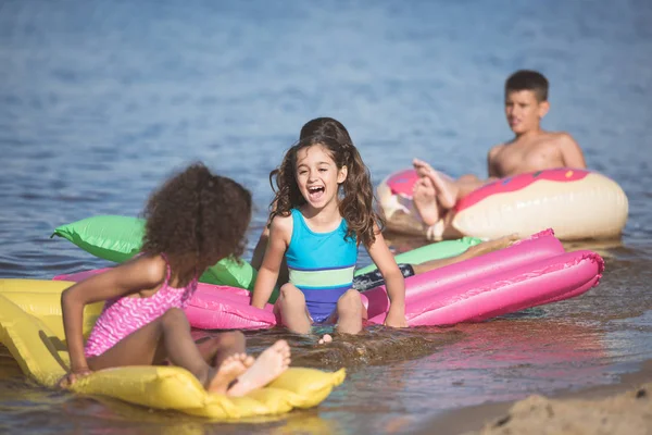 Kids have fun on inflatable mattresses — Stock Photo, Image