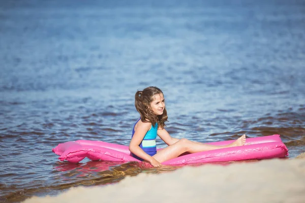 Little girl resting on inflatable mattress — Stock Photo, Image