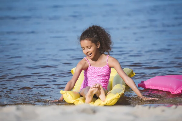 African american girl on inflatable mattress — Stock Photo, Image