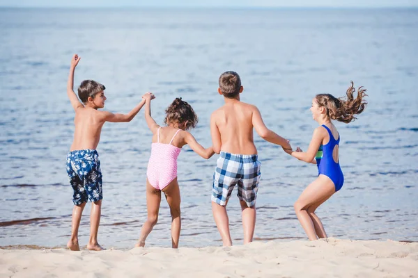 Children standing on sandy beash — Stock Photo, Image