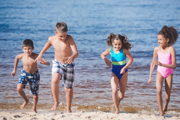 Multikulturelle Kinder spielen am Meer — Stockfoto