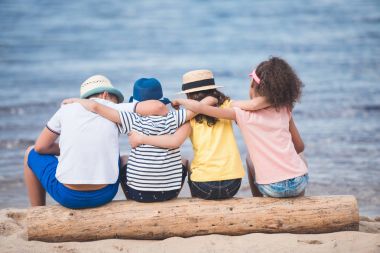 children sitting at seaside clipart