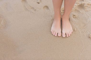 child standing on sandy beach clipart