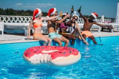 Multiethnic people at Christmas pool party  clipart
