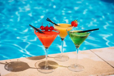 Colorful cocktails near pool clipart