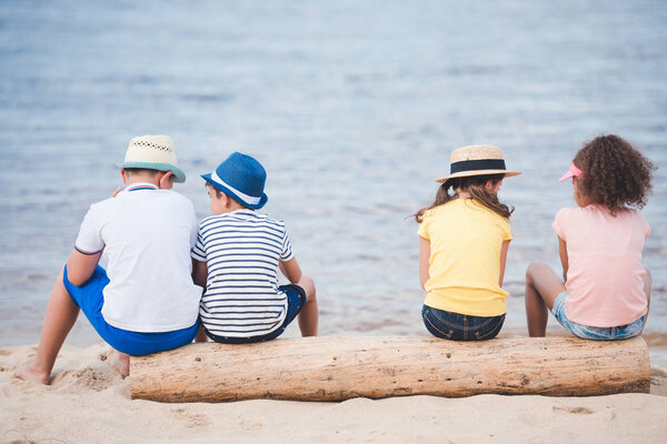 children sitting at seaside