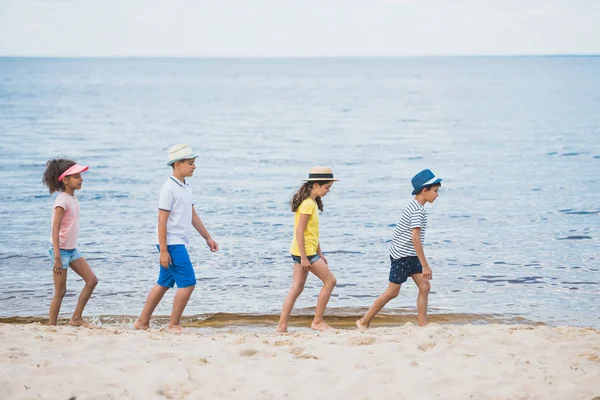 Enfants multiculturels marchant sur la plage — Photo