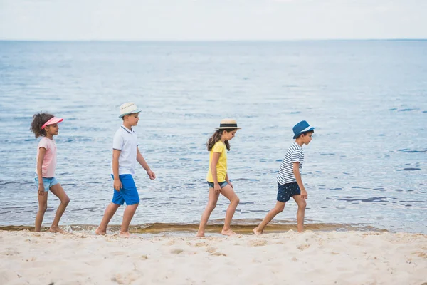 Crianças multiculturais andando na praia — Fotografia de Stock