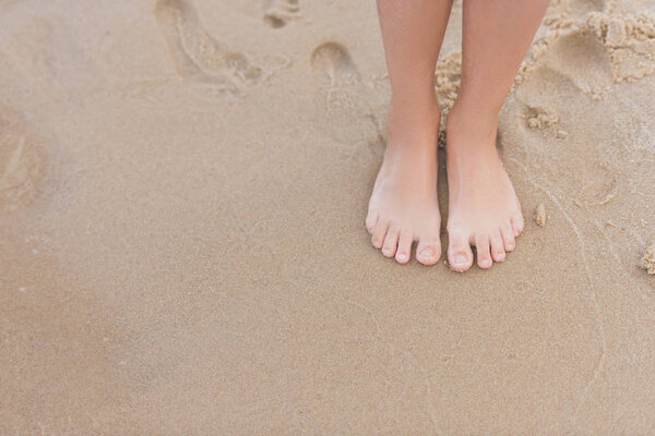 child standing on sandy beach