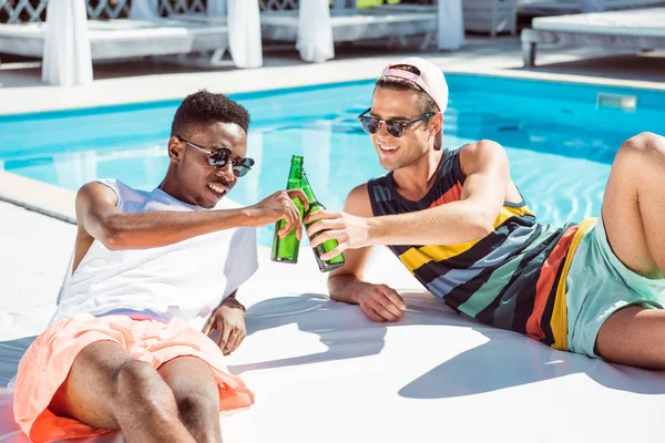 Homens multiétnicos com cerveja perto da piscina — Fotografia de Stock