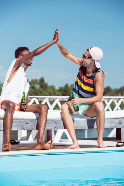 Multiethnic men with beer near pool — Stock Photo, Image