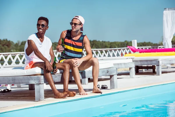 Multietniskt män med öl nära pool — Stockfoto