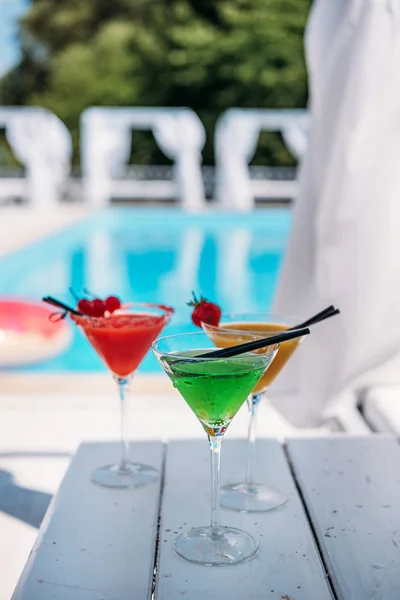 Färgglada drinkar nära pool — Stockfoto