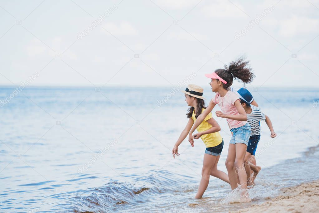 multicultural kids throwing stones at seaside