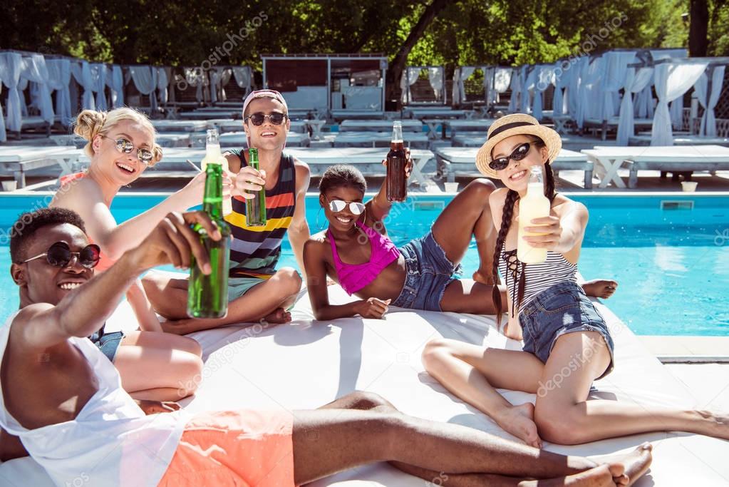 Multiethnic friends near pool at resort