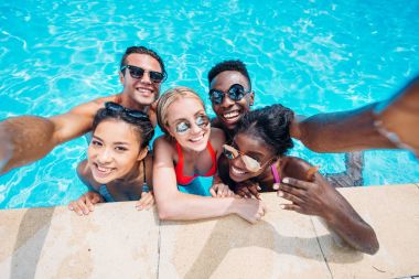 multiethnic people taking selfie in pool  clipart