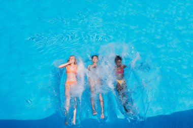 Multiethnic women swimming in pool clipart