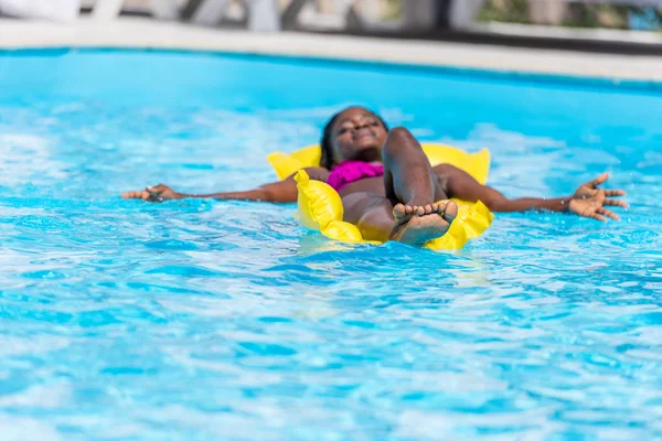 Vrouw op opblaasbare matras in zwembad — Stockfoto