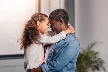 african american man holding daughter  clipart