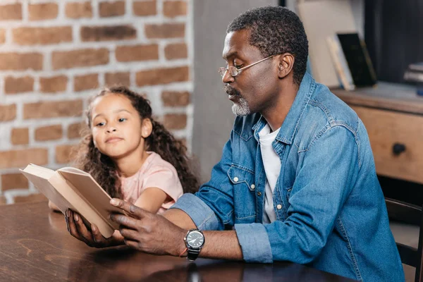 Mann liest Buch mit Tochter — Stockfoto