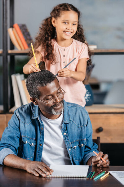 African american man drawing with daughter