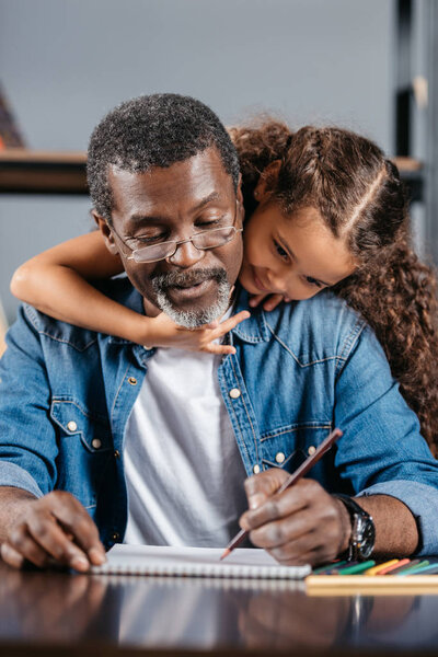 African american man drawing with daughter