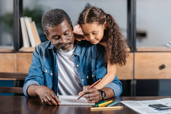 African american man tekenen met dochter — Stockfoto