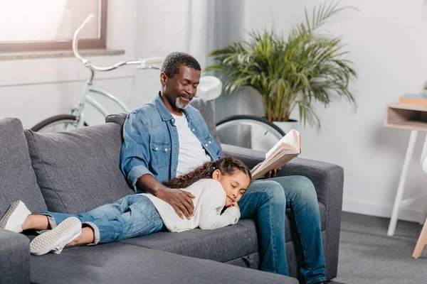 Uomo che legge il libro per la figlia a casa — Foto Stock