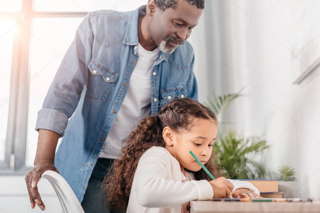 african american girl drawing with father