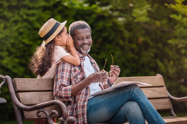 Grandchild whispering to her grandfather — Stock Photo, Image