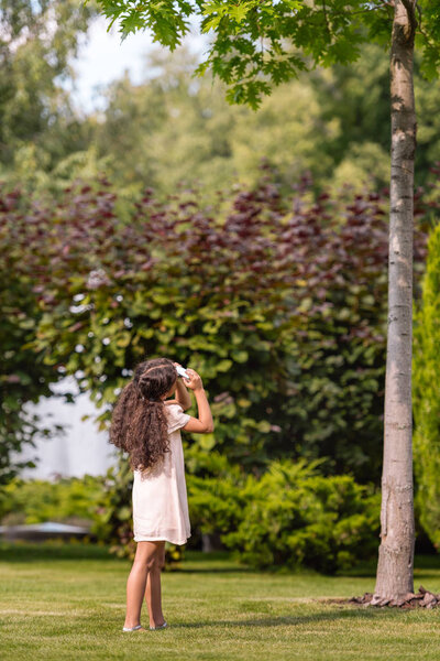 girl taking photo of tree