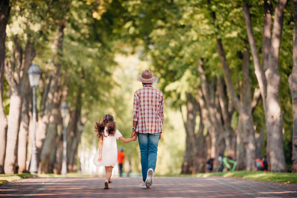 girl with grandfather and walking in alley 