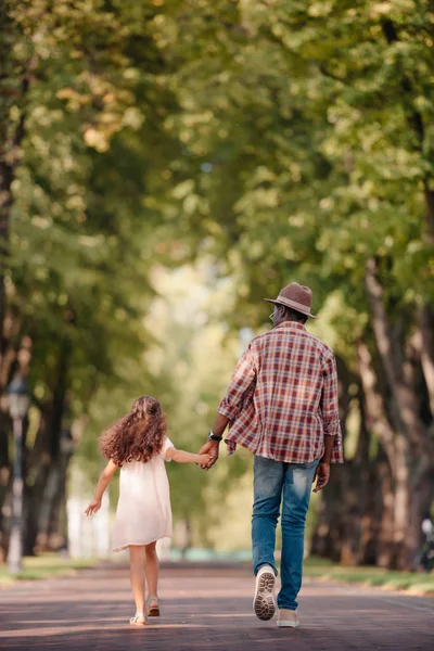 Girl with grandfather and walking in alley — Stock Photo, Image