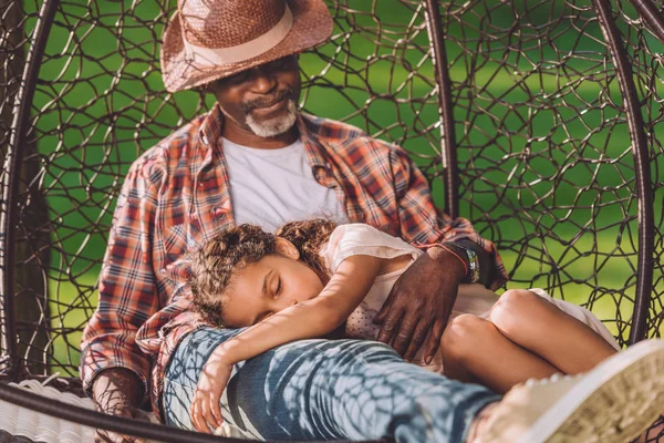 Granddaughter sleeping on laps of grandfather — Stock Photo, Image
