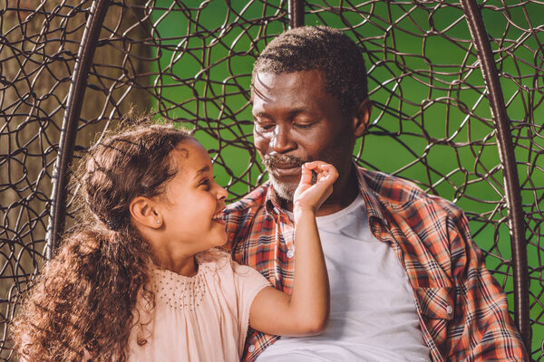 granddaughter and grandfather sitting in park