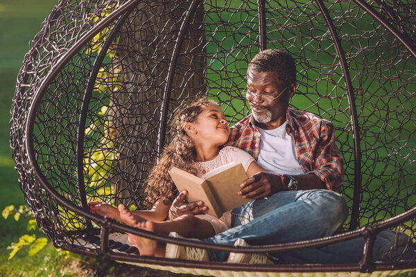 granddaughter and grandfather reading book 