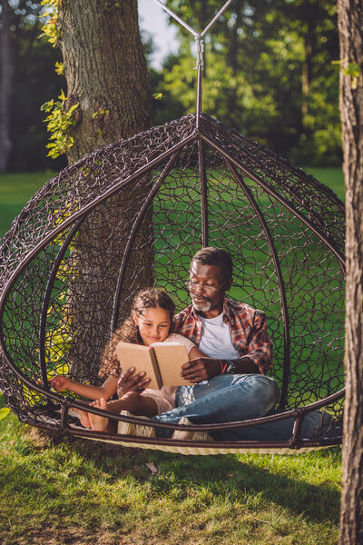 granddaughter and grandfather reading book 