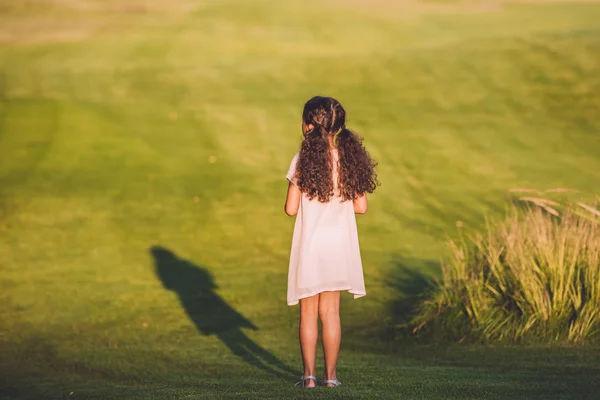Petite fille debout sur la pelouse — Photo