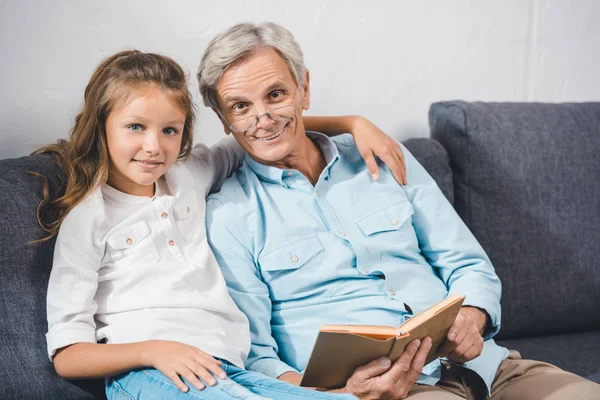 Grandfather and granddaughter reading book — Stock Photo, Image