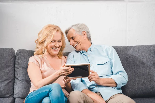 Pareja mirando marco de fotos — Foto de Stock