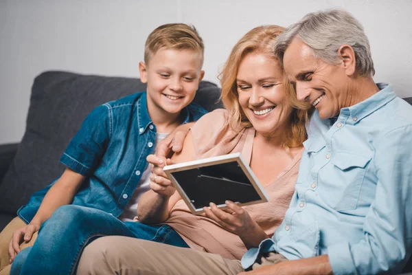 Familia mirando marco de fotos — Foto de Stock