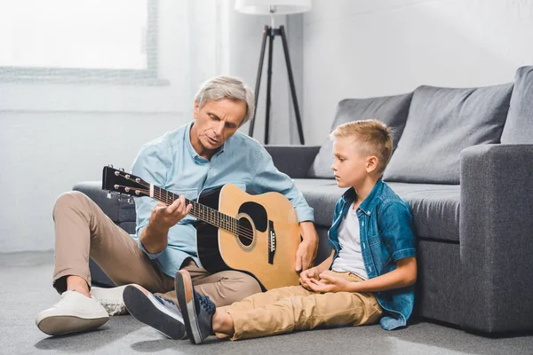 Grand-père et petit-fils jouant à la guitare — Photo