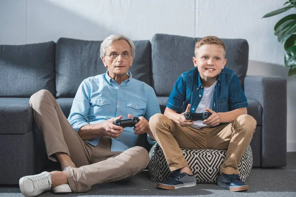 Дедушка и внук играют в видеоигры — стоковое фото