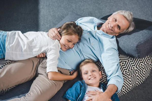 Opa en kleinkinderen liggend op de vloer — Stockfoto