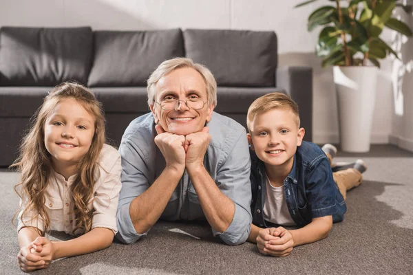 Glimlachend familie liggend op vloer — Gratis stockfoto