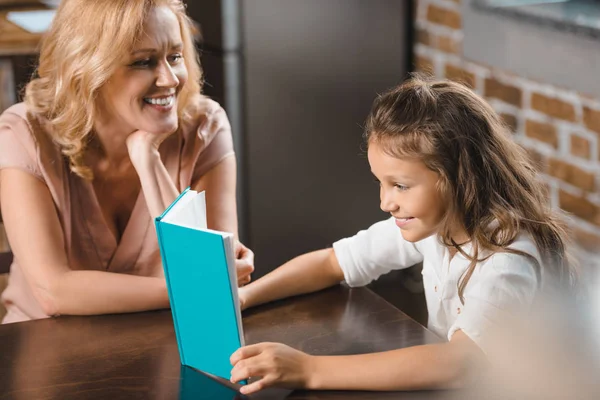 Grandmother and granddaughter reading book — Stock Photo, Image