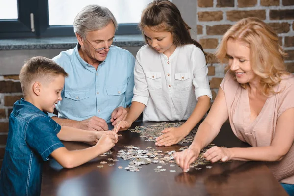 Familie spielt mit Puzzle — Stockfoto