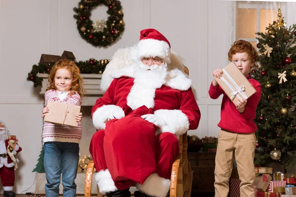 Weihnachtsmann und Kinder mit Geschenken — Stockfoto